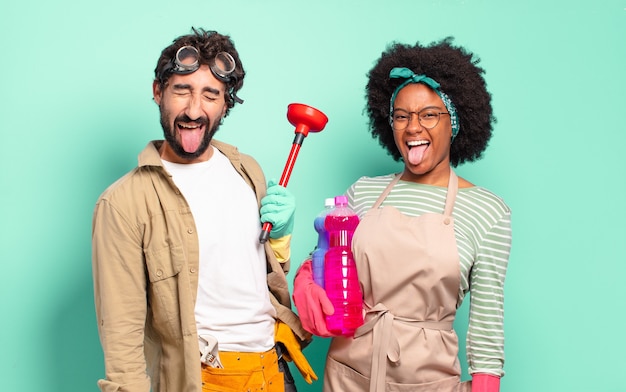 Mixed couple with cheerful, carefree, rebellious attitude, joking and sticking tongue out, having fun. housekeeping concept.. home repairs concept