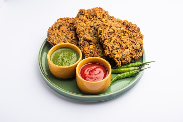 Mixed dal vada of pakoda is een indiase snack, geserveerd met tomatenketchup of groene chutney