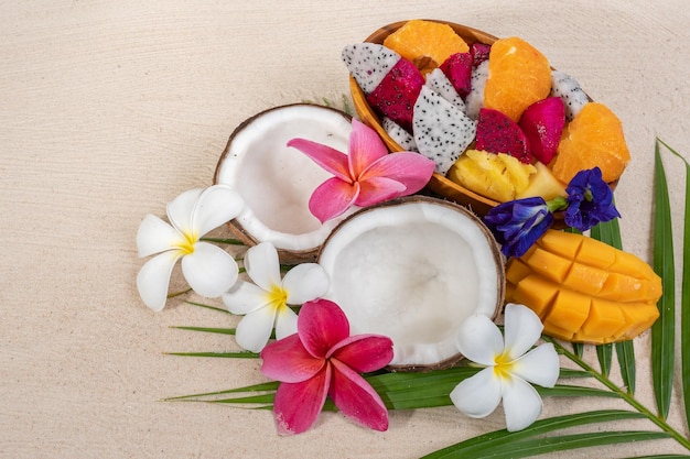 Mixed fruit bowl on palm leaf background.