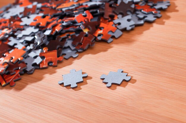 Mixed jigsaw puzzle peaces on wooden table