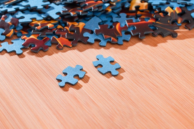 Mixed jigsaw puzzle peaces on wooden table