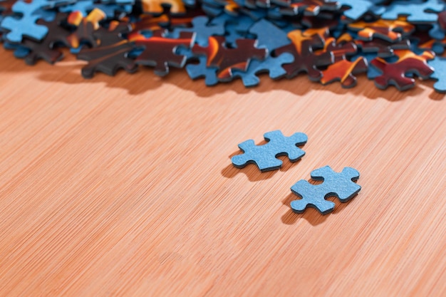 Mixed jigsaw puzzle peaces on wooden table