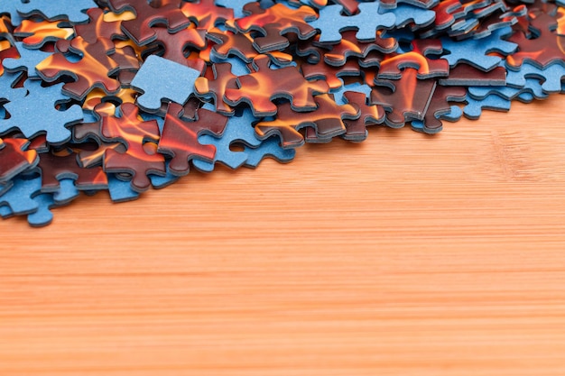 Mixed jigsaw puzzle peaces on wooden table