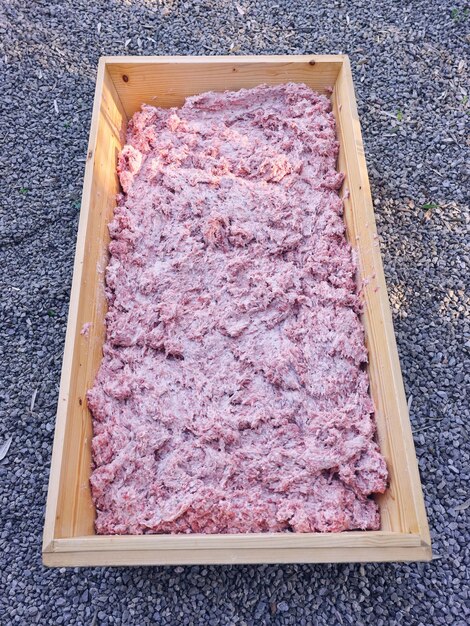 Mixed minced meat placed on wooden box on ground