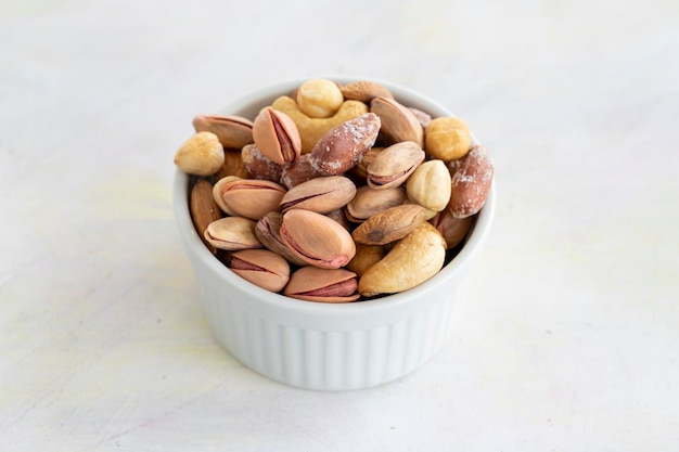 Mixed nuts in bowl on white background