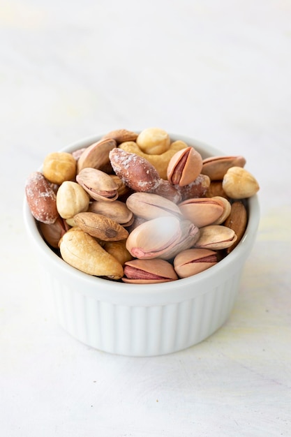 Mixed nuts in bowl on white background