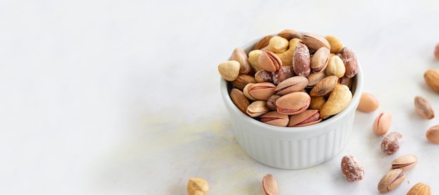 Mixed nuts in bowl on white background