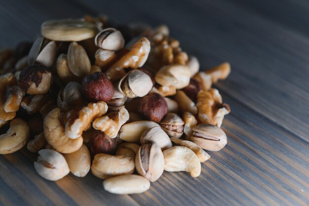 Mixed nuts in a bowl on wooden table top view with copy space