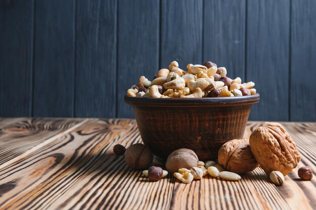 Mixed nuts in a bowl on wooden table top view with copy space