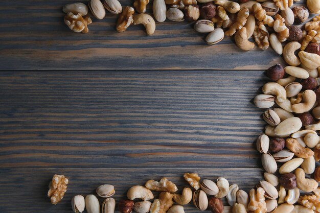 Mixed nuts in a bowl on wooden table top view with copy space