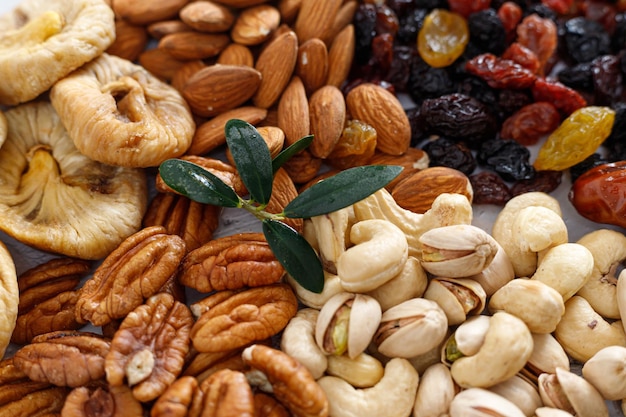 Photo mixed nuts and dried fruits on a light concrete background symbols of tu bishva