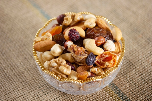 Mixed nuts in a glass plate Healthy and natural nutrition Cashew Almond Hazelnut Fig Walnut Apricot Raisin Blueberry