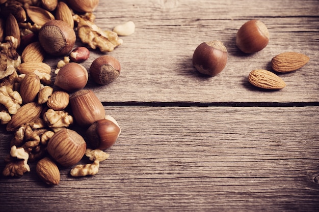 Mixed nuts on old wooden background