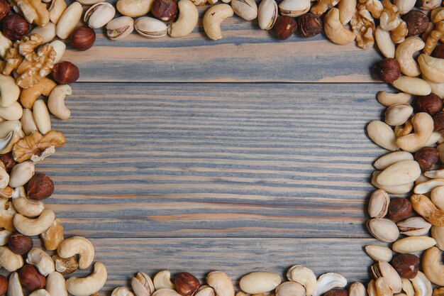 Photo mixed nuts on wood floor organic and fresh nuts copy space