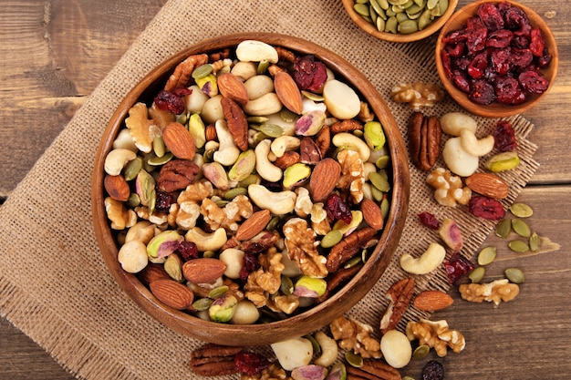 Photo mixed nuts in wooden bowl with linen mat