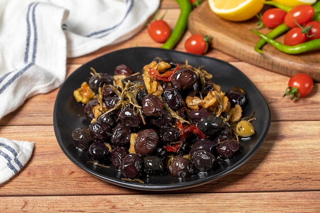 Mixed olives Dried tomatoes thyme rosemary walnuts and olives on the plate Mediterranean flavors