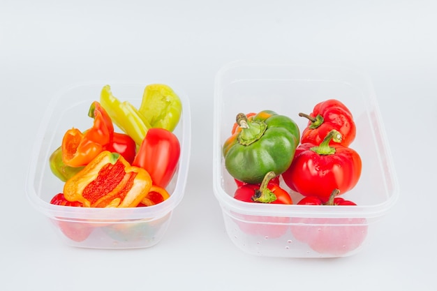 Mixed organic red green and yellow peppers in a container Storage of vegetables Organization of space in the kitchen