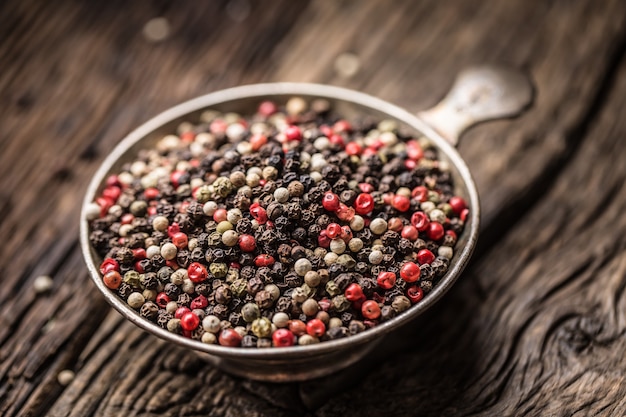 Mixed peppercorns red black and white in bowl - Close-up.