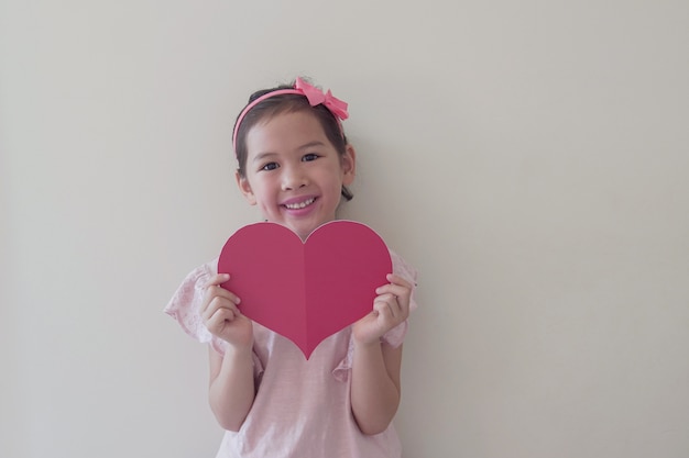 Mixed race child holding big red heart, heart health, donation,\
happy volunteer charity, social responsibility,world heart day,\
world health day,world mental health day, wellbeing, hope\
concept