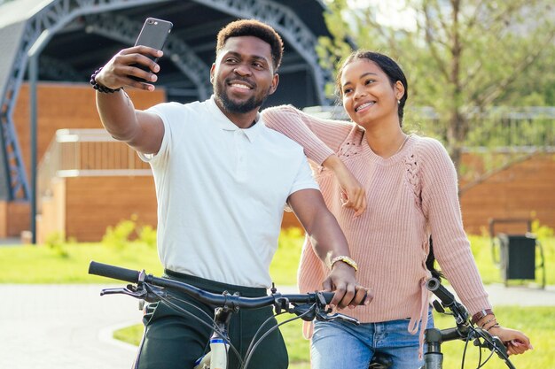 Mixed race couple taking a cycle on rent phone app