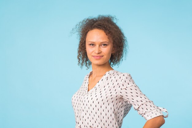 Mixed race female with Afro hairstyle wearing casual shirt over blue