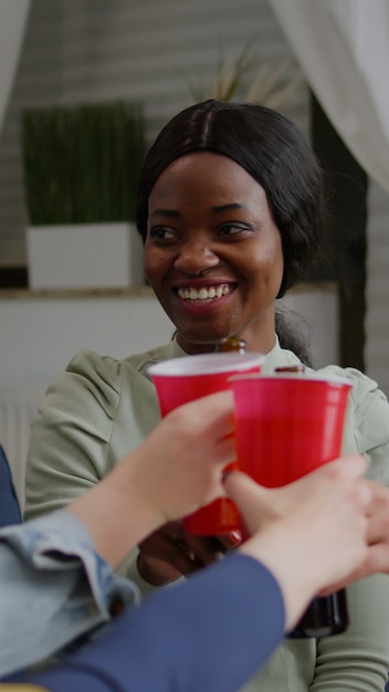 Mixed race friends socializing while sharing socia media advice relaxing on sofa late at night in living room