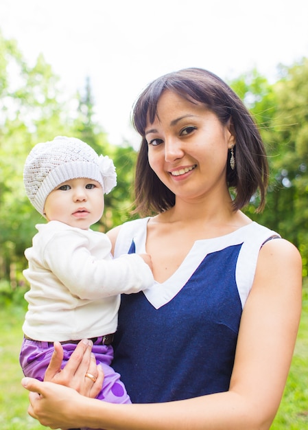 Mixed race happy mother with baby girl outdoors portrait.