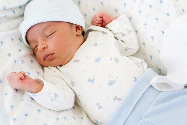 Mixed race infant boy sleeping in the baby cot