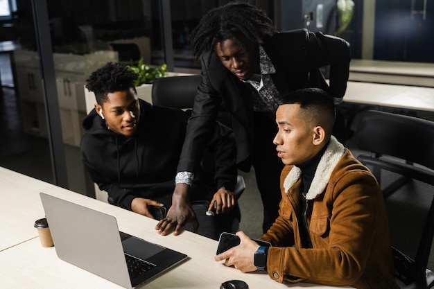 Mixed race of men teamwork on laptop in office Discussing and working on on online projects