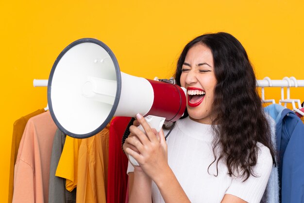 Mixed race Woman in a clothing store and holding a megaphone