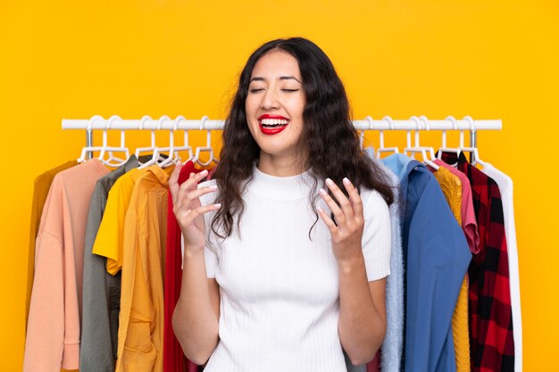 Mixed race woman in a clothing store laughing