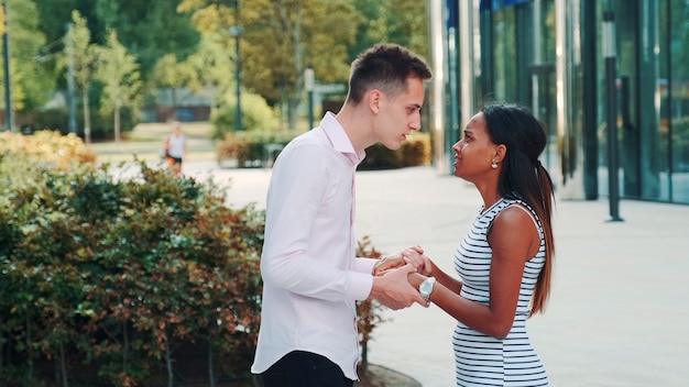 Photo mixed-race woman starts crying during the quarrel with her boyfriend in the street. he trying to calm her, but he isn't lucky.