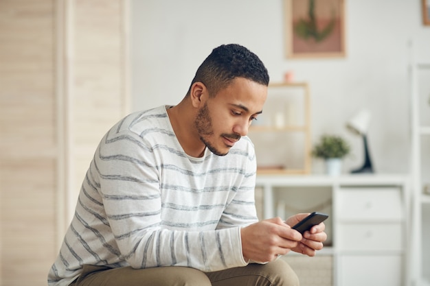 Mixed-Race Young Man Using Smartphone