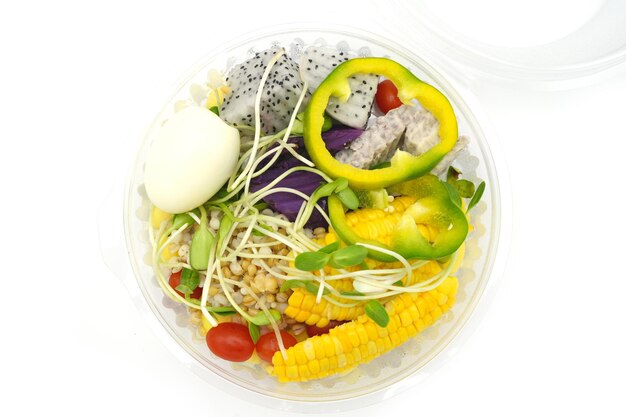 Mixed salad in clear plastic box
on white background