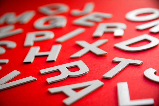 Mixed solid letters pile close up view photo. Education concept on red background.