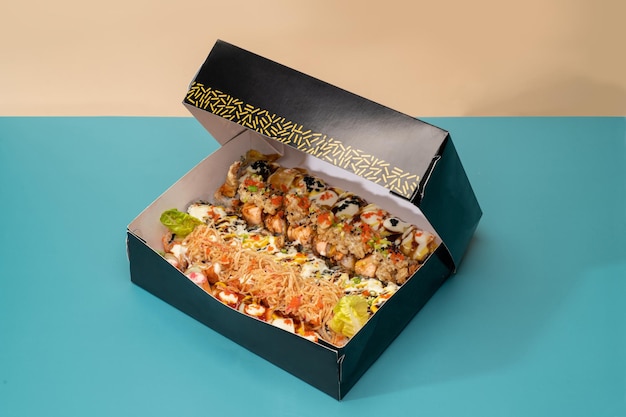 Mixed sushi platter served in a box isolated on blue background side view of japanese fast food