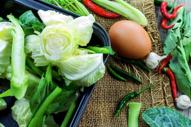 Mixed vegetables and egg on the wooden table.