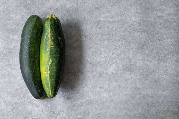 Mixed yellow, white, stripped and green zucchini's on a grey concrete background