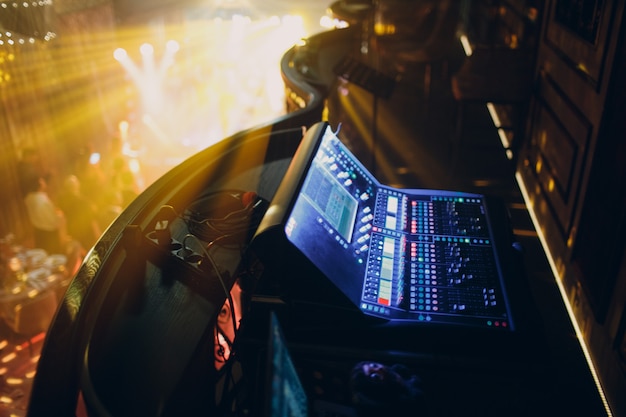 Photo mixing console, hand equalizing audio sound channels in night club