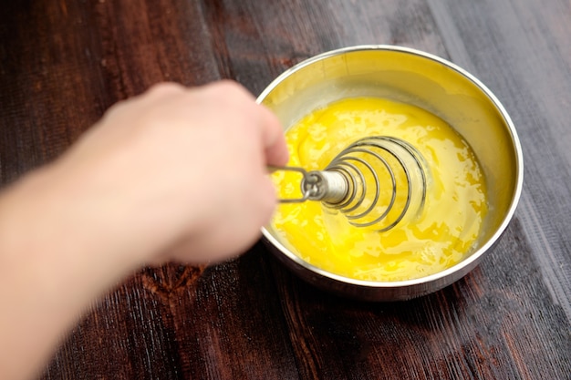 Mixing eggs in steel bowl using whisk