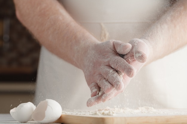写真 ボウルに小麦粉とイーストを手で混ぜて、パンを調理する
