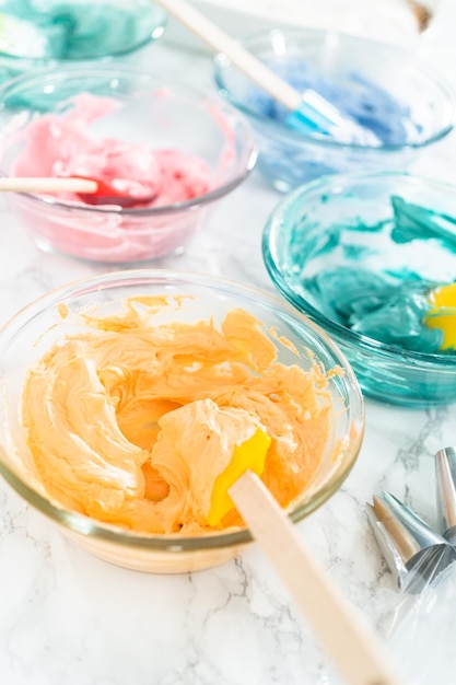 Mixing food coloring with Italian buttercream frosting.