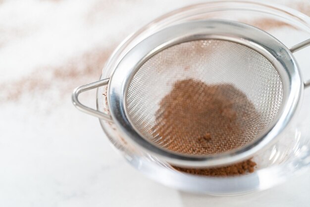 Mixing ingredients in a glass mixing bowl to bake chocolate graham crackers