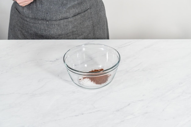 Mixing ingredients in a glass mixing bowl to bake chocolate graham crackers