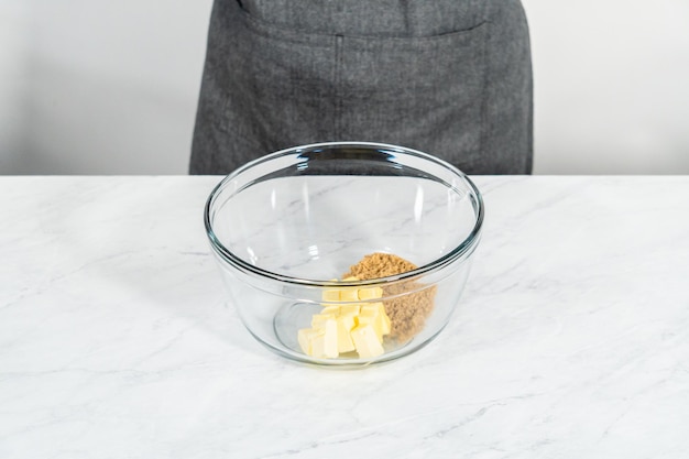 Mixing ingredients in a glass mixing bowl to bake mascarpone tart with fresh berries.