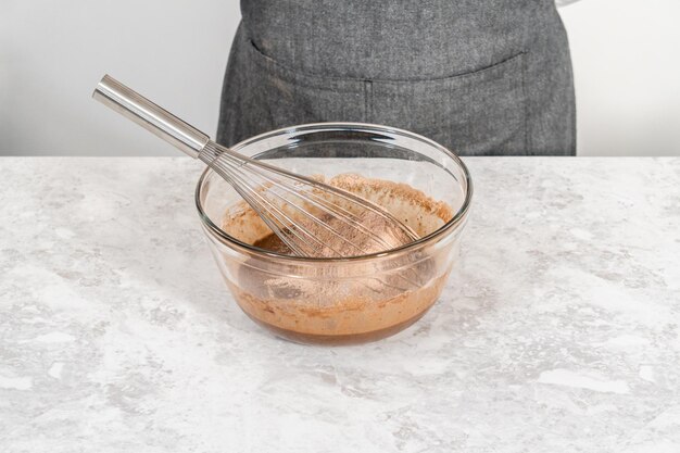 Mixing ingredients in a glass mixing bowl to bake s'mores cupcakes.