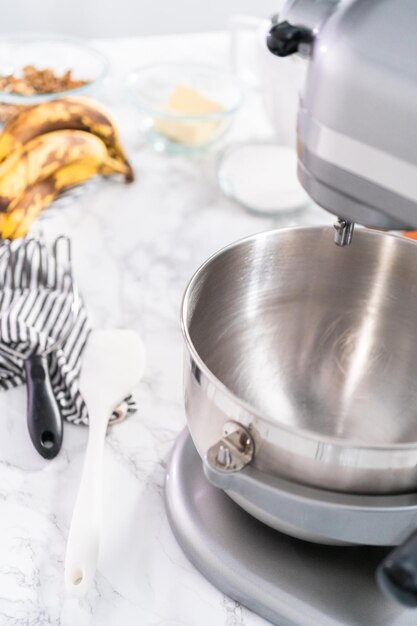 Mixing ingredients in kitchen mixer to bake banana nut bread.