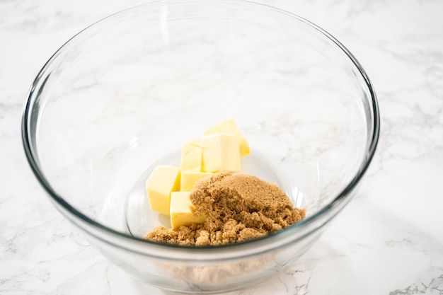 Mixing ingredients in a large glass mixing bowl to bake gingerbread cupcakes.