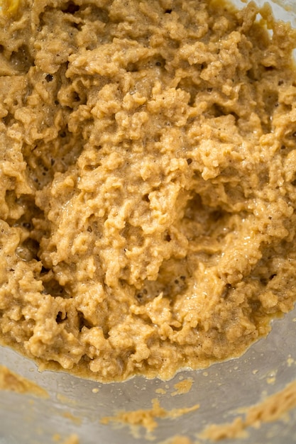 Mixing ingredients in a large glass mixing bowl with a kitchen mixer to bake chocolate cookies with peppermint chips.