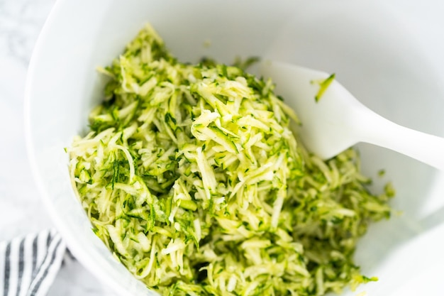 Mixing ingredients in mixing bowl to make zucchini cakes.